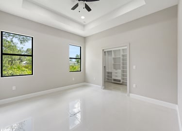 Master bedroom with porcelain tile, two windows and entrace to the walking in closet