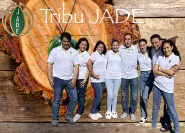 Tribu Jade team members posing in white polo shirts against a rustic wood log background.