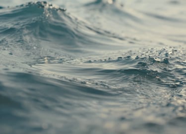 An abstract close-up of moving water or fabric, suggesting motion for a GIF or video still. The colors are a blend of soft blue-grey and muted teal with bright off-white highlights, captured with a professional, sharp lens.