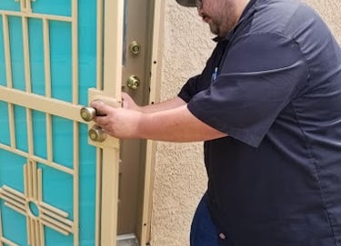 a man in a black shirt and jeans standing in front of a door