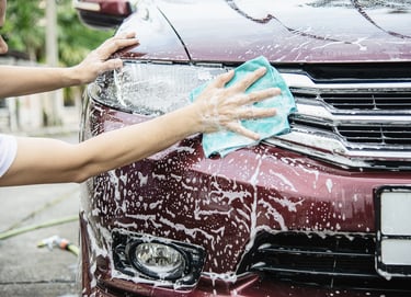 a woman is cleaning a car with a cloth