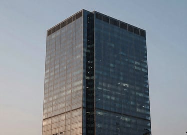 An architectural detail of a contemporary South American / Brazilian skyscraper against a twilight sky, showcasing glass and steel in muted steel blue and pale grayish blue hues.