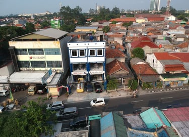 a city street scene with a car parked in front of a building gedung kantor putra delima mandiri