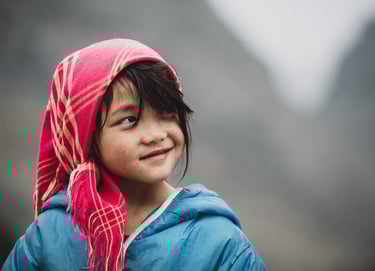 a young girl wearing a pink scarf and a pink scarf