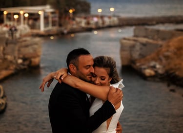 durante la sessione fotografica di coppia, gli sposi si abbracciano teneramente sullo sfondo di un canale al tramonto