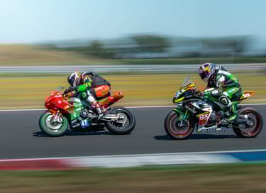two people riding motorcycles on a track
