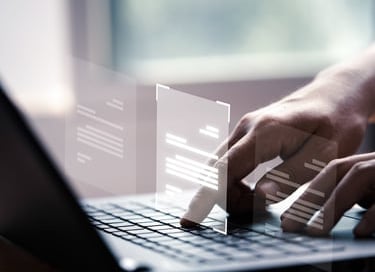 a person typing on a laptop computer screen