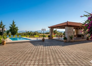 Luxury outdoor patio with swimming pool, stone pavilion, and mountain views.