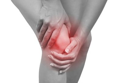 A person holding their knee with a red glow indicating chronic joint pain and inflammation.