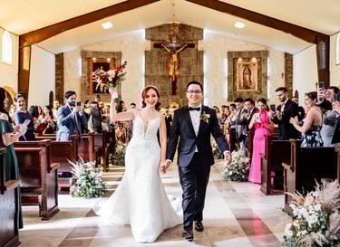 a bride and groom walking down the aisle of a church