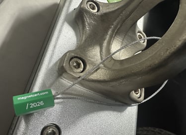 Green MagnetCert compliance tag attached to a lifting magnet