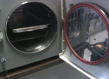 esterilizador de vapor con puerta abierta y charola de acero inoxidable