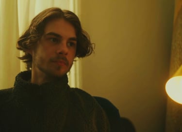 a man in a black sweater and a light bulb on a lamp