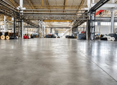 Spacious industrial warehouse with polished concrete floors and high steel ceilings.
