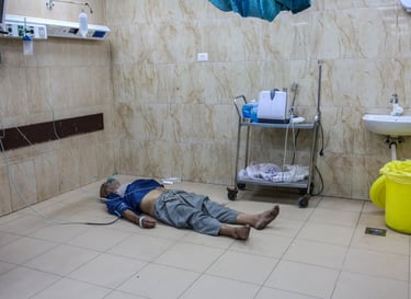 A patient lying on a hospital floor getting oxygen and IV to medical facility unavailable mass loss 