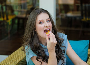 Foto da nutricionista em Jaraguá do Sul, Kamila Kuester, sorrindo enquanto come brigadeiro branco