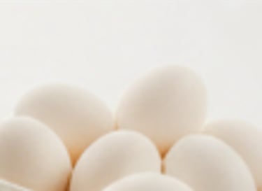 Close up photo of white eggs stacked together.