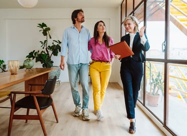 a man and woman walking through a room with a laptop