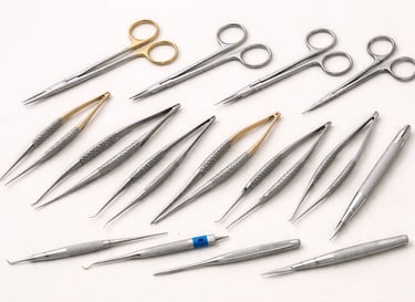Microsurgical instruments like small scissors, forceps, and needle holders on a white background.
