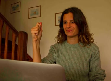 Laura Capit sitting at a table with a laptop computer