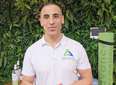 wollongong Massage Therapist in white shirt and green plant wall behind