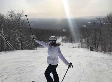 Female skier in a white jacket and helmet posing on a snowy mountain ski  resort Lake Louise Canada