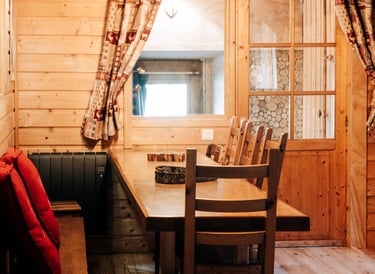 The wooden dining table in the Russian barn seen from the living room 