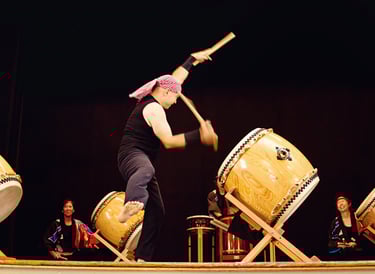 taiko artist Mark H Rooney drumming on stage