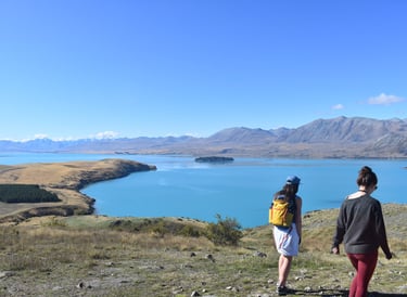 travellers walking by lake tekapo in south island of new zealand