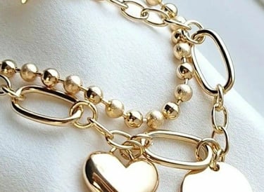 Elegante pulsera con dije de corazón y colgante de disco circular en una cadena de eslabones