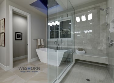 Modern luxury bathroom featuring a freestanding soaking tub and glass walk-in shower with stone tile.