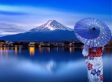 Woman in traditional Japanese kimono holding a blue parasol overlooking Mount Fuji at Lake Kawaguchi.