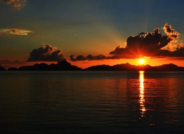 Traditional boat sailing in El Nido bay during a golden sunset dinner cruise