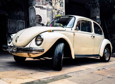 a white volkswagen beetle beetle parked on a sidewalk