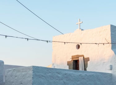 a church with a cross on the top of a hill