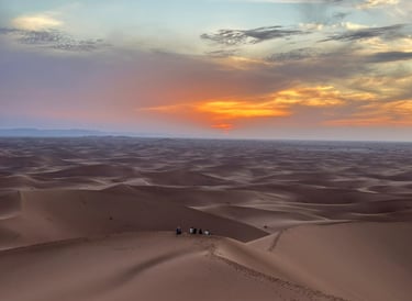 A view across the Moroccan Sahara from atop a dune at sunset