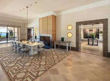 Dining room at Villa La Gratitud with fireplace, modern lighting, and terrace views toward the sea. 