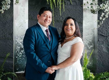 Retrato de bodas de recién casados tomados de la mano en un espacio elegante con plantas y cascadas en Quito Ecuador