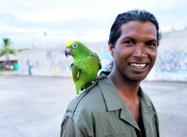 Un homme et son perroquet prennent la pose devant l'appareil photo
