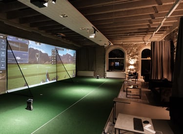 a man is playing golf in a room with a large screen