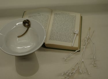 Assemblage including a porcelain vessel with sculptural bronze knot detail and Iris Murdoch novel 