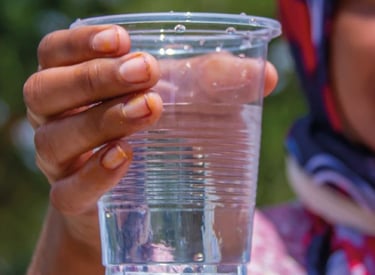 Eine Frau hält einen Becher Wasser