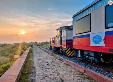Heritage narrow-gauge train crossing Sambhar Lake at sunrise, bathed in golden light.