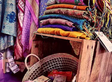 Folded vintage Indian sarees stacked in warm, earthy tones.