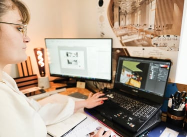 a woman sitting at a desk with a laptop and a notebook