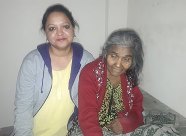 a woman sitting on a bed with an old woman