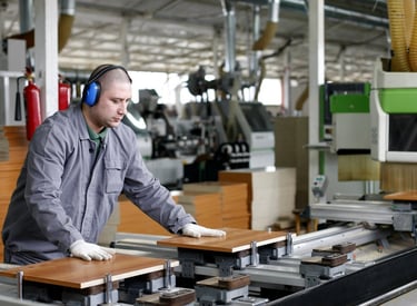 a man in a gray jacket and headphones on a machine