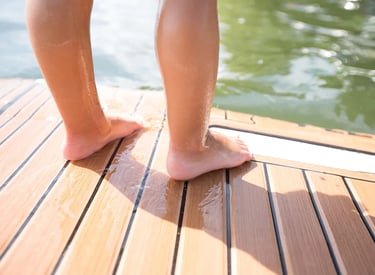 Feet standing on foam teak deck on a boat and enjoying the soft feel