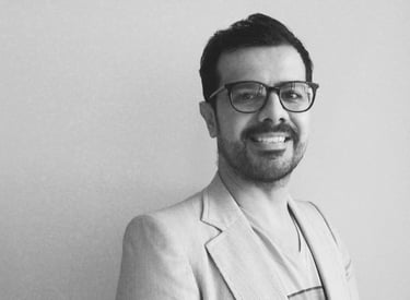 a man in a suit and glasses smiling