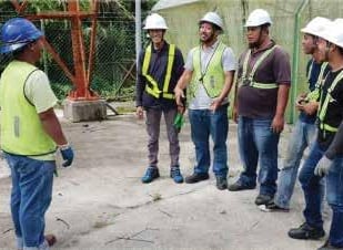 a group of men in safety vests standing in a circle